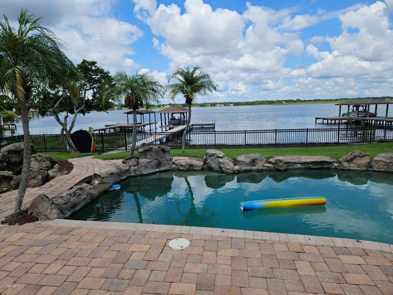 Lakefront pool before renovation with natural rock features